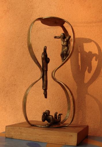 trois personnages dans un sablier pour voquer le temps qui passe. bronze de flore de valicourt